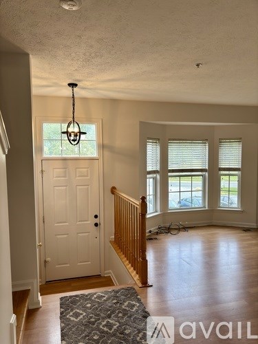A room with a white door, a window with blinds, and a bicycle in the background.