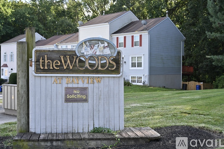 A sign for "The Woods at Bayview" is displayed in front of a building.