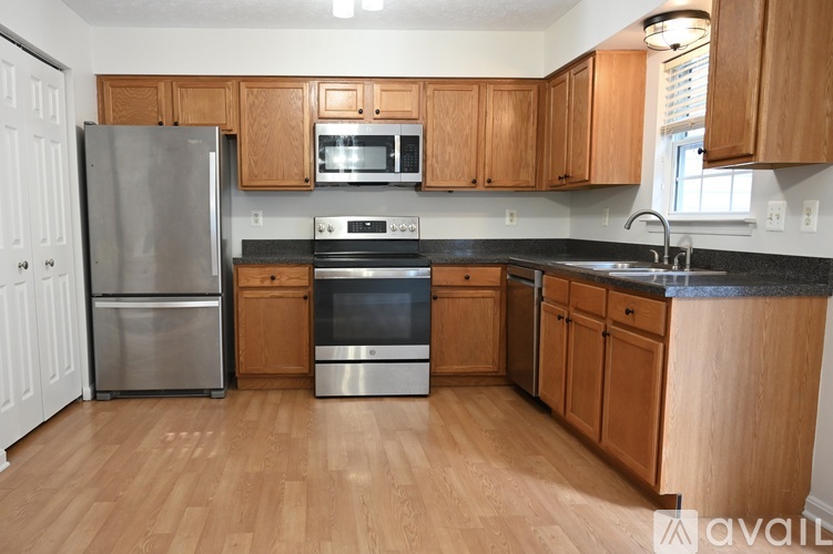 A kitchen with wooden cabinets and a black countertop.