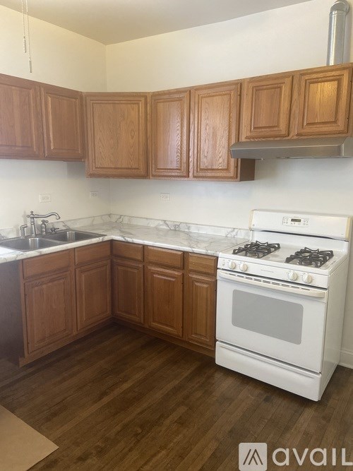 A kitchen with wooden cabinets and a white stove top oven.