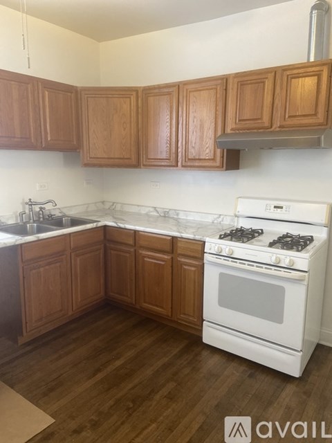 A kitchen with wooden cabinets and a white stove top oven.