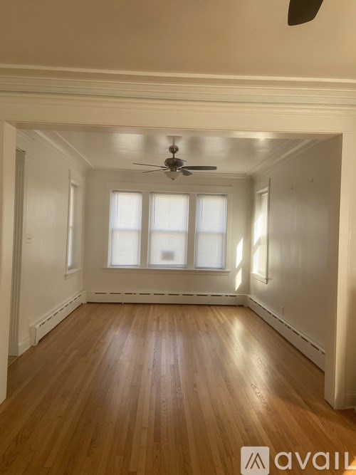 A room with wooden floors and a ceiling fan.