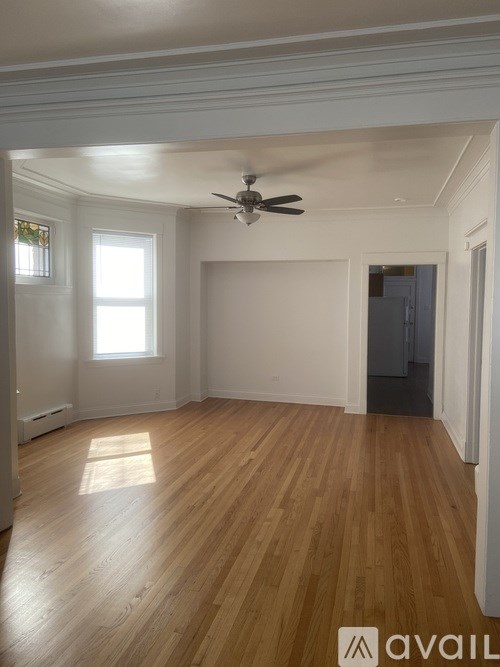 A room with wooden floors and a ceiling fan.