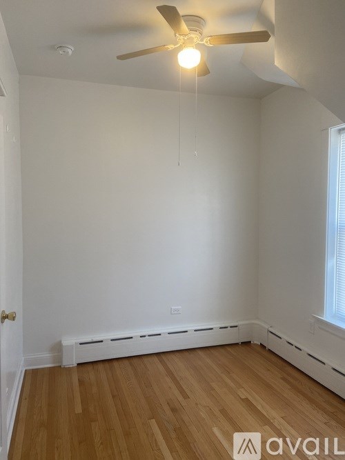 A room with wooden floors and a ceiling fan.