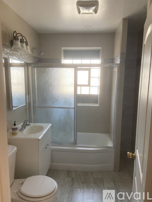 A bathroom with a toilet, sink, and tub.