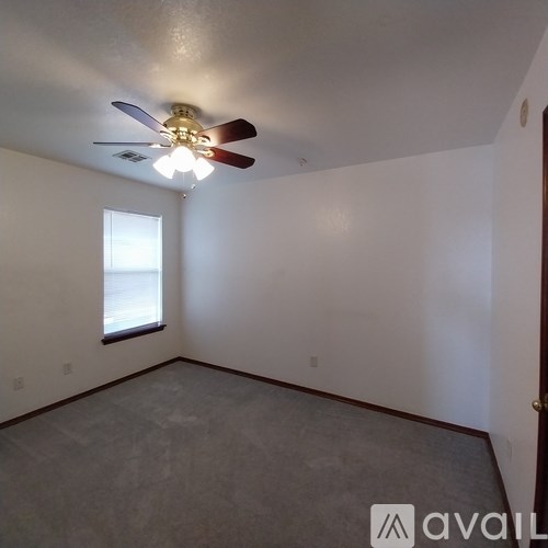 A room with a ceiling fan and a window.