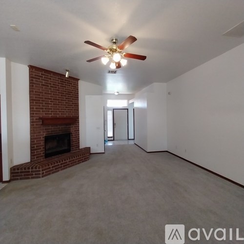 A room with a fireplace and a ceiling fan.