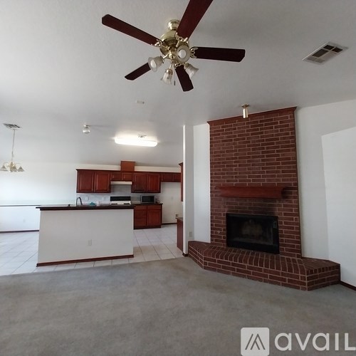 A living room with a fireplace and a ceiling fan.