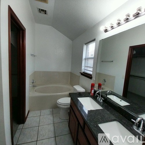 A bathroom with a tub, toilet, and sink.