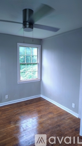 A room with a ceiling fan and a window.