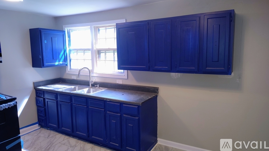 A kitchen with blue cabinets and a window.
