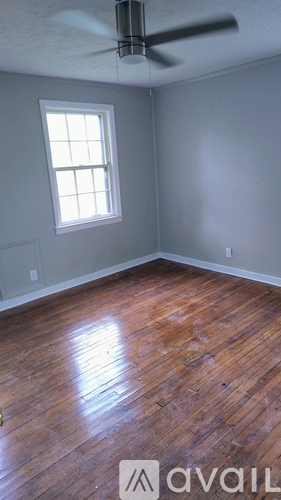 A room with a ceiling fan and a window.