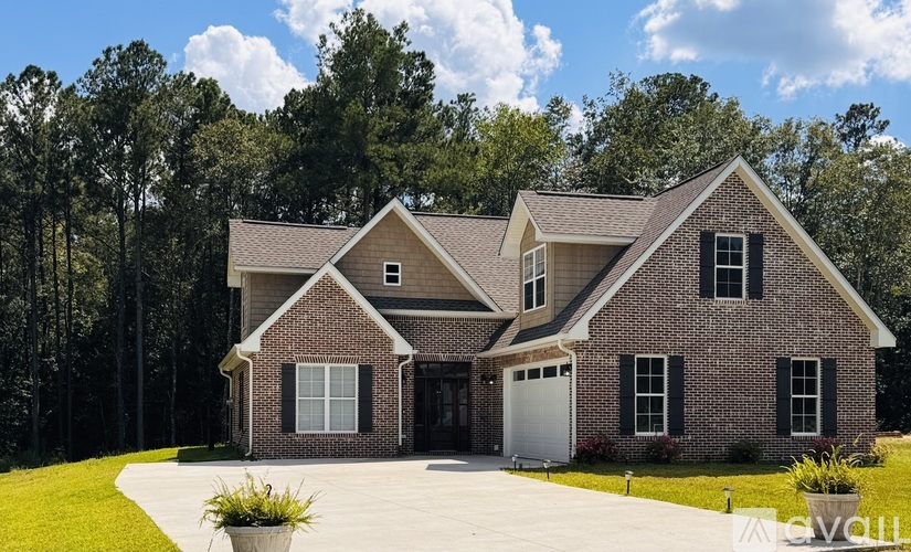 A brick house with a garage door and a driveway.