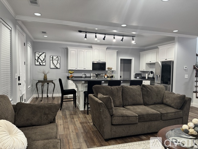 A kitchen with white cabinets and a black countertop.