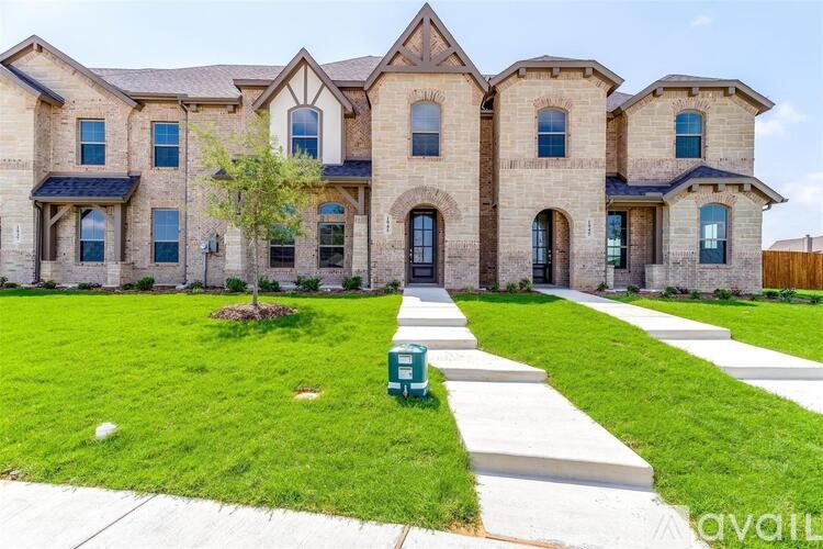 A large, multi-story house with a front yard and a driveway.