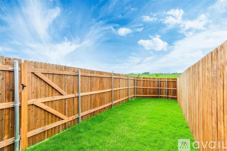 A wooden fence encloses a green lawn.