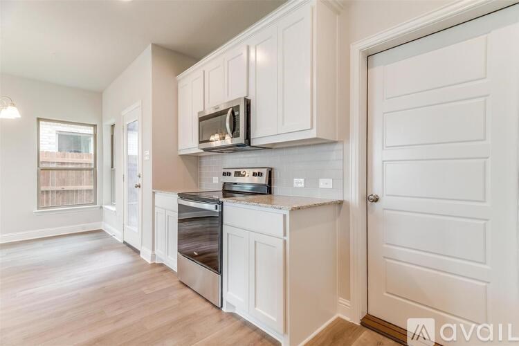 A kitchen with white cabinets and a stainless steel oven.