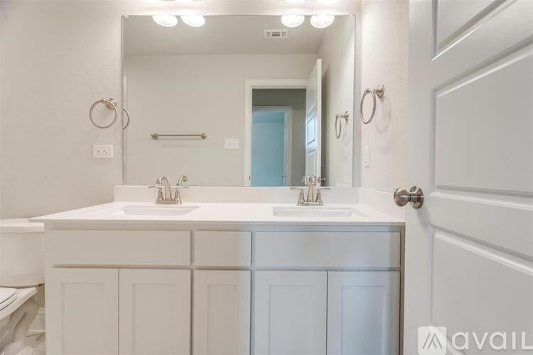 A bathroom with a white vanity and a mirror above it.