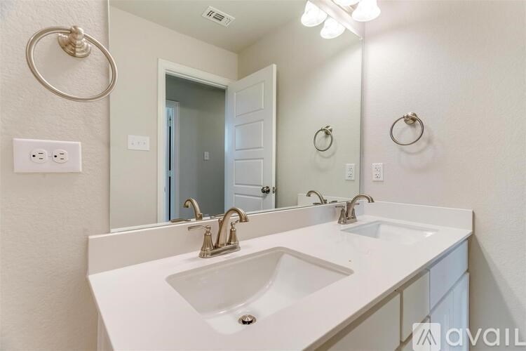 A bathroom with a white sink and mirror.