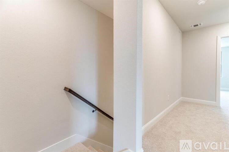 A room with a carpeted floor and a staircase.
