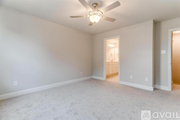 A spacious room with a ceiling fan and carpeted floor.