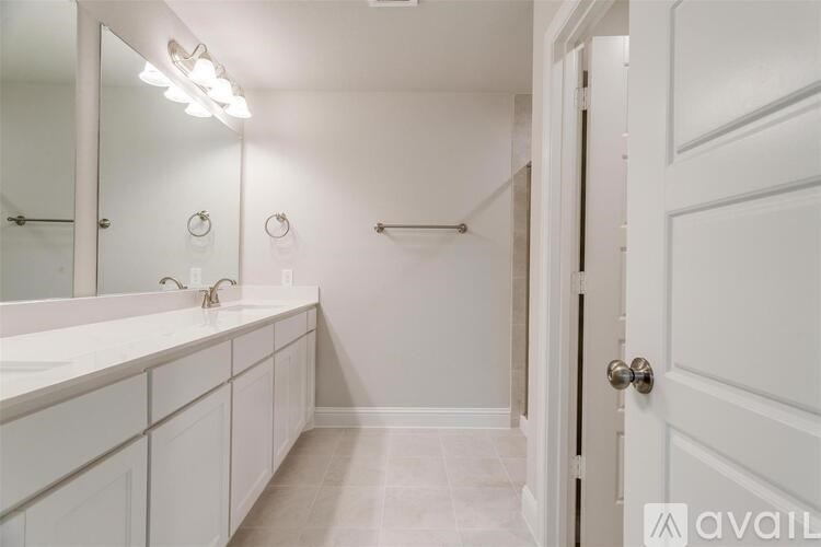 A bathroom with a white sink and a white door.