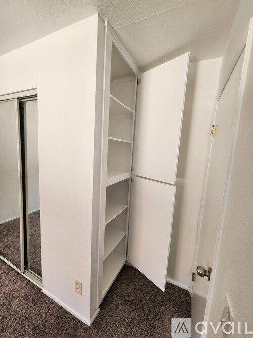 A white closet with a mirror on the door.