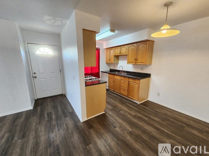 A kitchen with wooden cabinets and a white door.