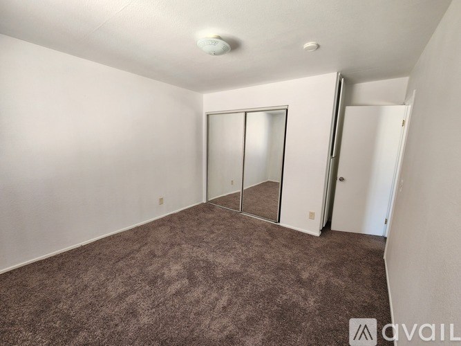 A room with a carpeted floor and a sliding door.