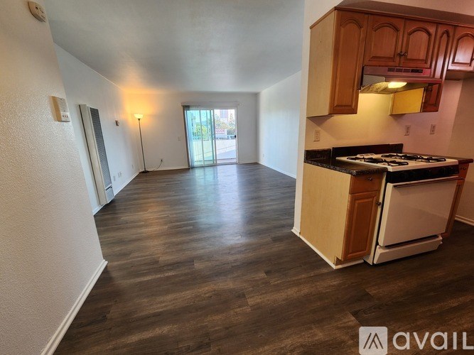 A kitchen with a stove top oven and wooden cabinets.