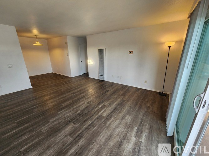 A room with wooden flooring and white walls.