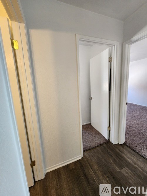A hallway with a closed door and a carpeted floor.