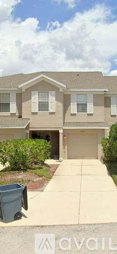 A two-story house with a garage and a driveway.