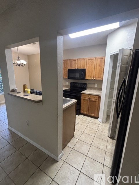 A kitchen with a black fridge and white cabinets.