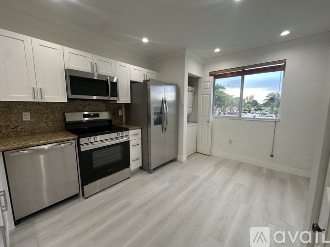 A kitchen with stainless steel appliances and white cabinets.