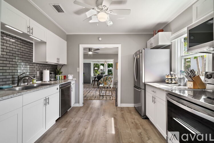 A modern kitchen with white cabinets and stainless steel appliances.
