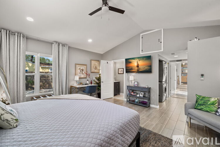 A bedroom with a large bed and a ceiling fan.