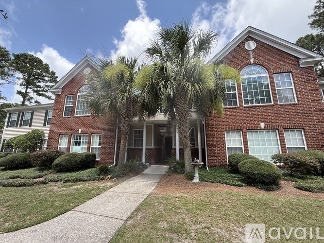 A house with a brick facade and a large front porch.
