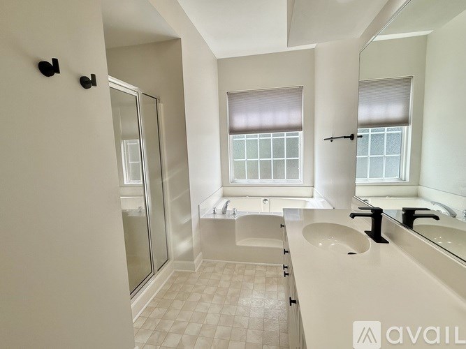 A bathroom with a large mirror, sink, and shower.