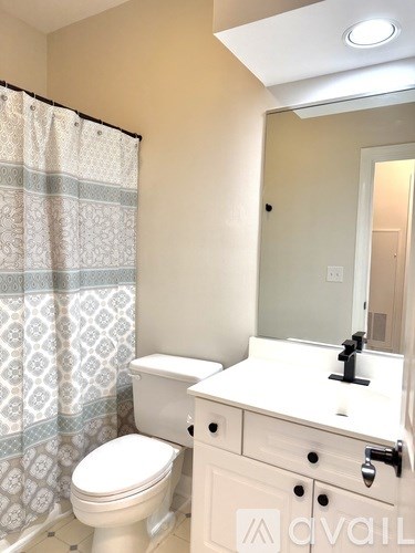 A white toilet sits next to a sink in a bathroom.
