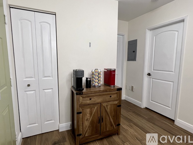 A room with a wooden cabinet and a white door.