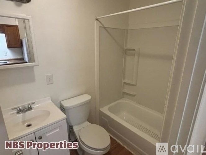 A white bathroom with a toilet, sink, and bathtub.