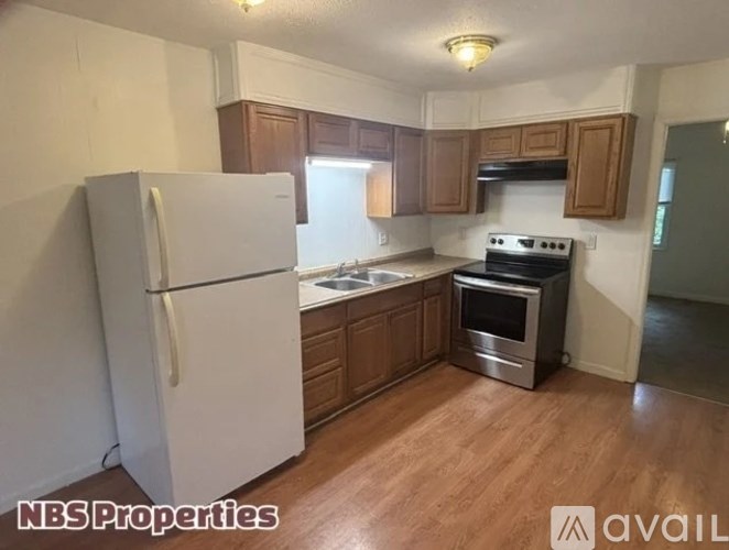 A kitchen with a white refrigerator and wooden cabinets.