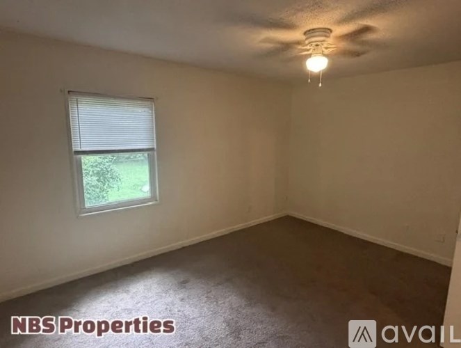 A room with a window and a ceiling fan.