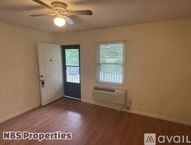 A room with a door, window, and a ceiling fan.