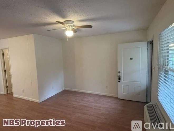 A room with a ceiling fan and a door is available for rent.