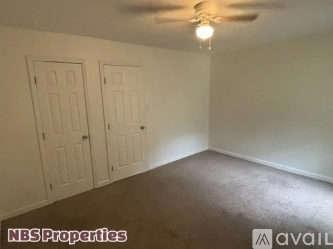 A room with two doors and a carpeted floor.