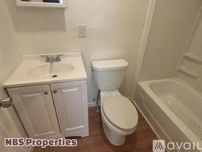A white toilet sits next to a sink in a small bathroom.