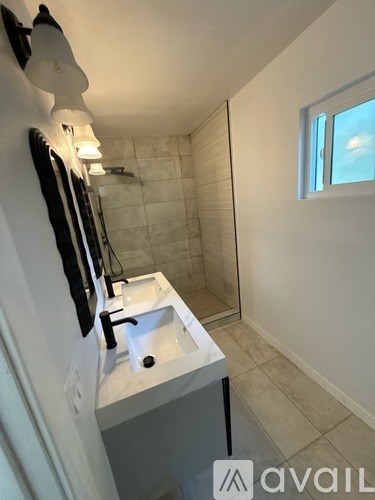 A backyard with a green lawn and a white house.