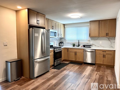 A kitchen with wooden cabinets and a stainless steel refrigerator.